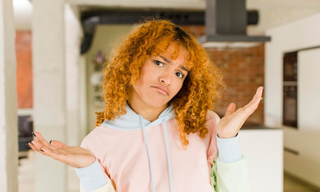 Jonge roodharige Latijnse mooie vrouw in een nieuw cool huis