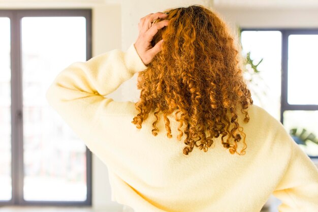 Jonge roodharige Latijnse mooie vrouw in een nieuw cool huis