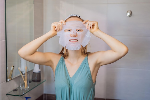 Jonge roodharige vrouw die het blad van het gezichtsmasker doet Schoonheid en het Concept van de Huidzorg