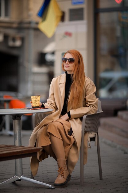 jonge roodharige vrouw die koffie drinkt in een café