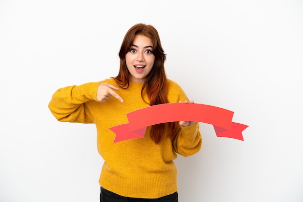 Jonge roodharige vrouw geïsoleerd op een witte achtergrond met een leeg bordje met verbaasde expression