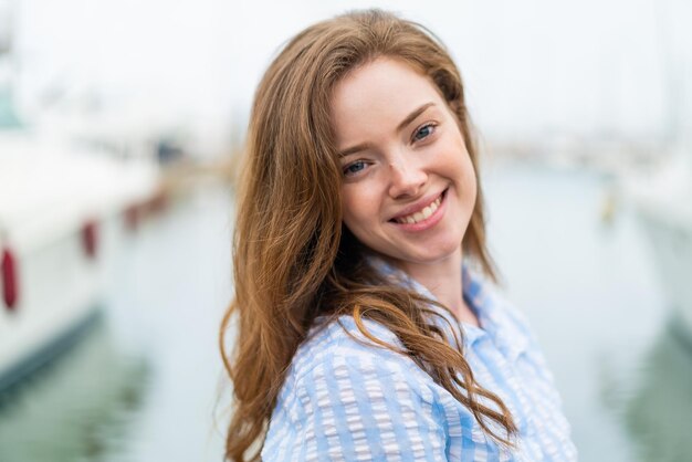 Jonge roodharige vrouw in de open lucht Met gelukkige uitdrukking