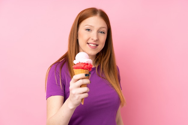 Jonge roodharigevrouw met een cornetroomijs met gelukkige uitdrukking