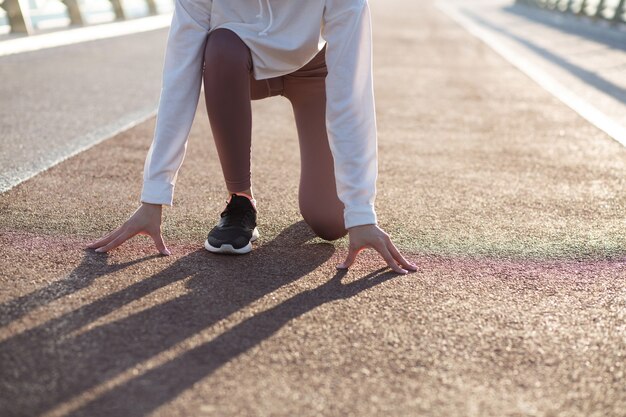 Jonge runner vrouw in de startpositie is klaar om te rennen. Ruimte voor tekst