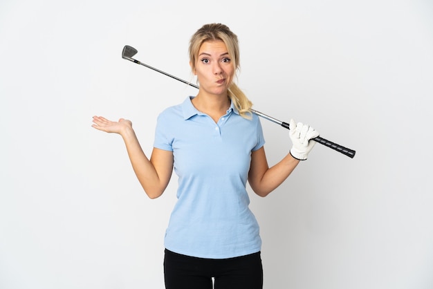 Jonge Russische golfervrouw die op witte achtergrond wordt geïsoleerd die twijfels heeft terwijl het opheffen van handen
