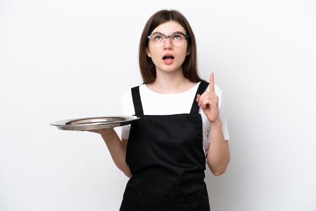 Jonge Russische vrouw chef-kok met dienblad geïsoleerd op een witte achtergrond denken een idee met de vinger omhoog