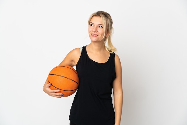 Jonge Russische vrouw die basketbal speelt geïsoleerd op een witte achtergrond die een idee denkt terwijl ze omhoog kijkt