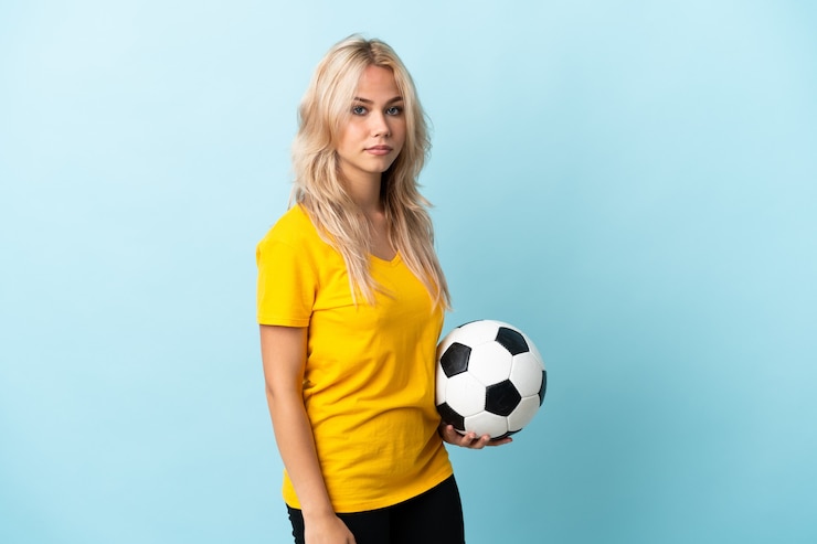 Foto jonge russische vrouw geïsoleerd op blauwe muur met voetbal