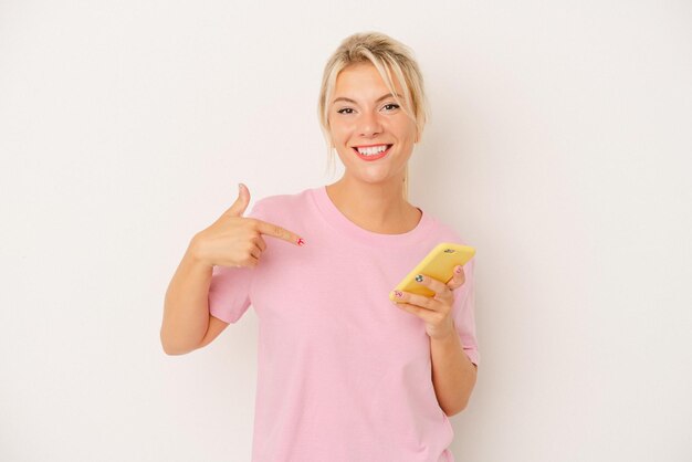 Jonge Russische vrouw met mobiele telefoon geïsoleerd op een witte achtergrond persoon die met de hand wijst naar een shirt kopieerruimte trots en zelfverzekerd?