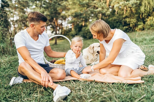 Jonge schattige familie op picknick met hond