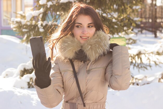 Jonge schoonheidsvrouw in winterpark in koude winterdag