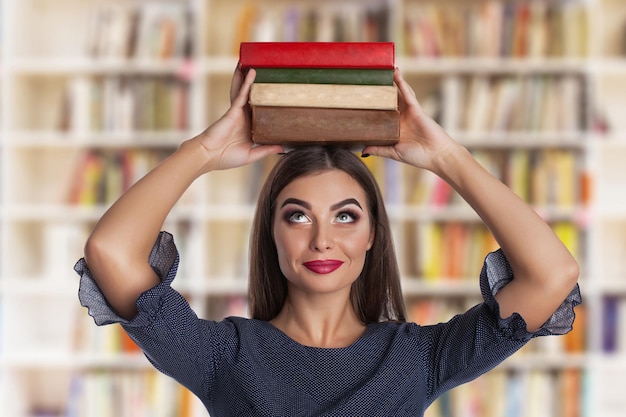 Jonge schoonheidsvrouw met boeken in bibliotheek