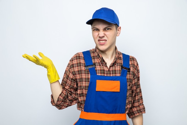 Jonge schoonmaakster met uniform en pet met handschoenen geïsoleerd op een witte muur