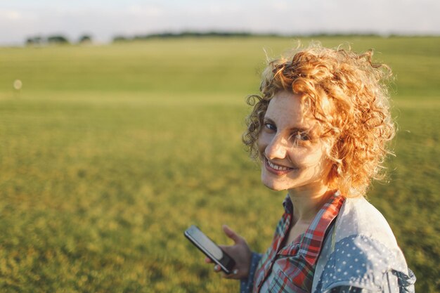 Foto jonge, serene vrouw die naar de camera kijkt op het platteland.