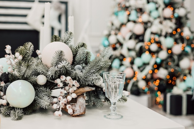 Jonge sexy vrouw in witte jurk zit in de buurt van de kerstboom