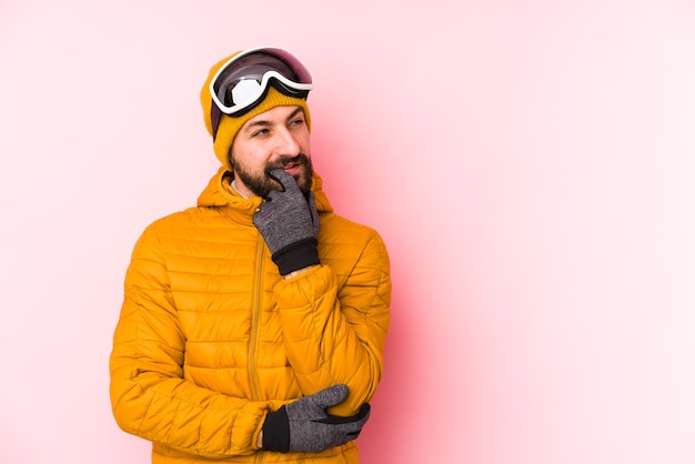 Jonge skiër man geïsoleerd ontspannen denken aan iets kijken naar een kopie ruimte.