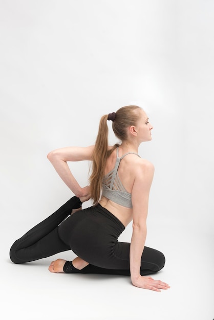 Jonge slanke vrouw beoefent yoga. Gymnastiek opleiding. Oefeningen om flexibiliteit te ontwikkelen. Verticaal kader