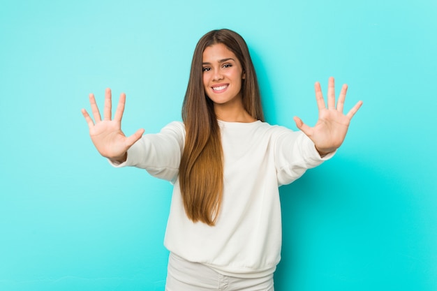 Jonge slanke vrouw die nummer tien met handen toont.