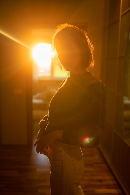 Jonge slanke vrouw poseert thuis onder zonlicht