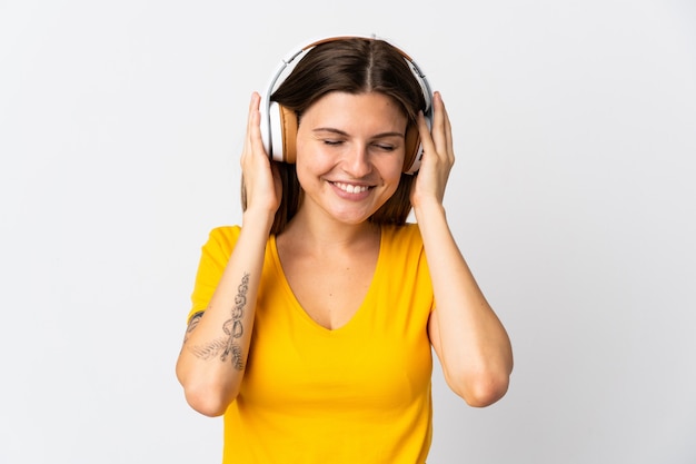 Jonge slowaakse vrouw geïsoleerd op een witte muur luisteren muziek