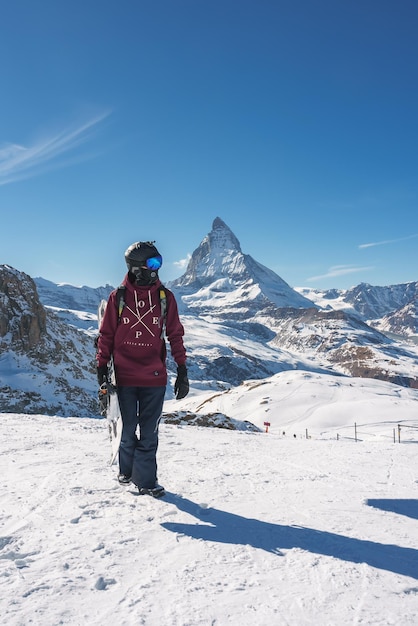 Jonge snowboarder brengt wintervakantie door in zermatt in de buurt van de beroemde Matterhorn-piek