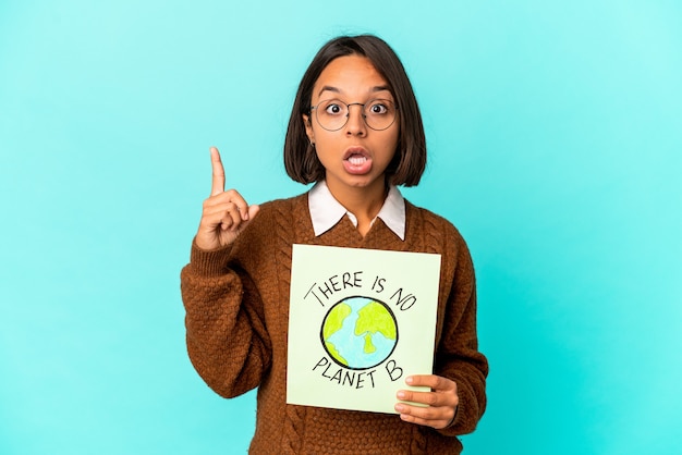 Jonge Spaanse gemengde rasvrouw die een planeet houden sparen aanplakbiljet met een idee