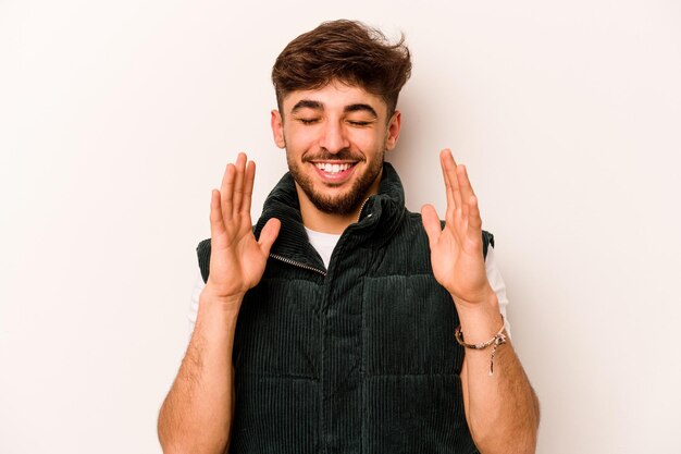 Jonge Spaanse man geïsoleerd op een witte achtergrond vrolijk lachen veel Geluk concept