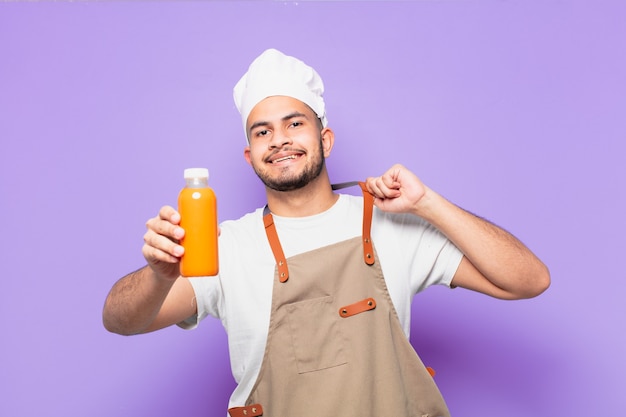 Jonge Spaanse man gelukkig expressie. chef-kok met een smoothy