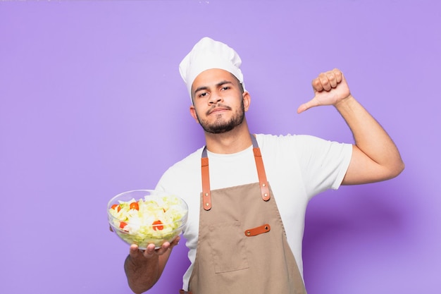 Jonge Spaanse man gelukkige uitdrukking. chef-kok met een saladeconcept