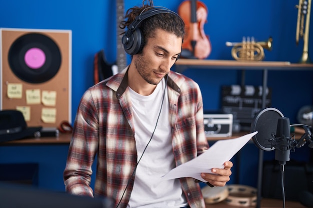 Jonge Spaanse man muzikant zingt lied in muziekstudio