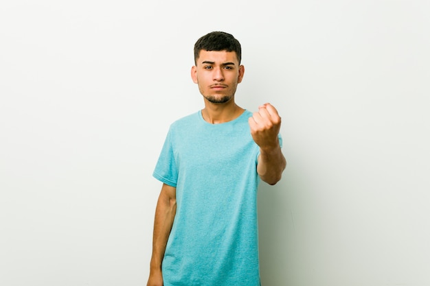 Jonge Spaanse mens die vuist toont aan camera, agressieve gelaatsuitdrukking.
