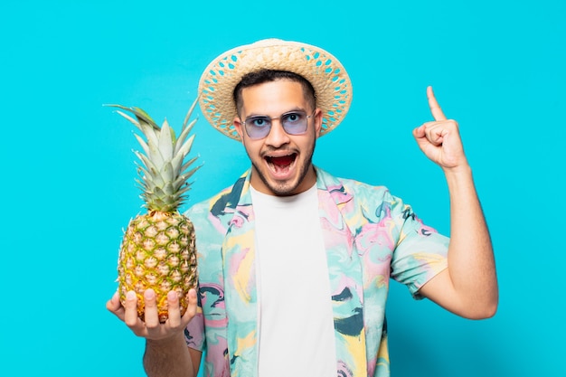 Jonge Spaanse reizigersmens die een overwinning succesvol viert en een ananas houdt