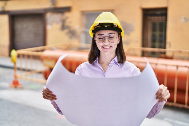 Jonge spaanse vrouw architect leest plannen op straat