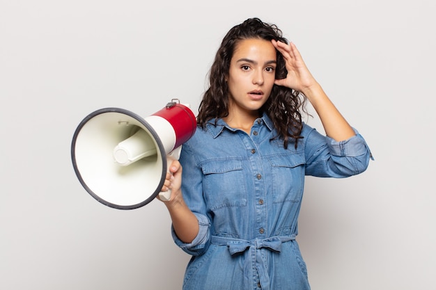 Jonge Spaanse vrouw die er blij, verbaasd en verrast uitzag, lachte en zich verbluffend en ongelooflijk goed nieuws realiseerde