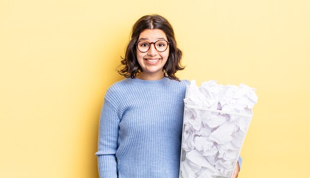 Jonge Spaanse vrouw die er gelukkig en aangenaam verrast uitziet, faalt afvalconcept