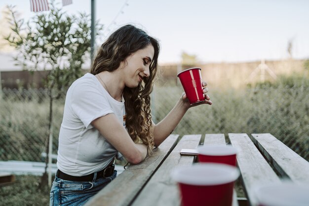 Jonge Spaanse vrouw die in het park drinkt tijdens