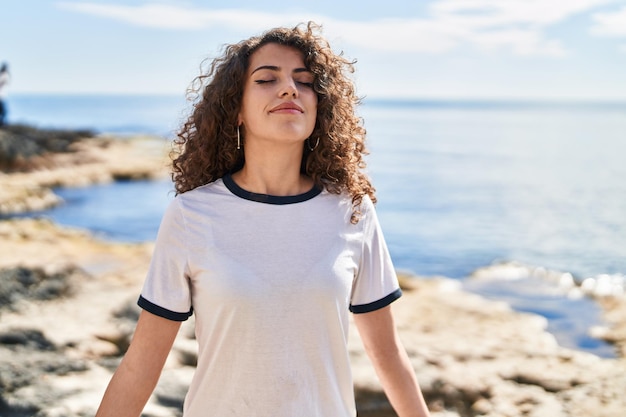 Jonge spaanse vrouw die lacht zelfverzekerd ademen aan zee