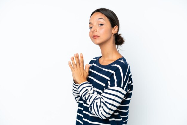 Jonge spaanse vrouw die op witte achtergrond wordt geïsoleerd die iets plannen
