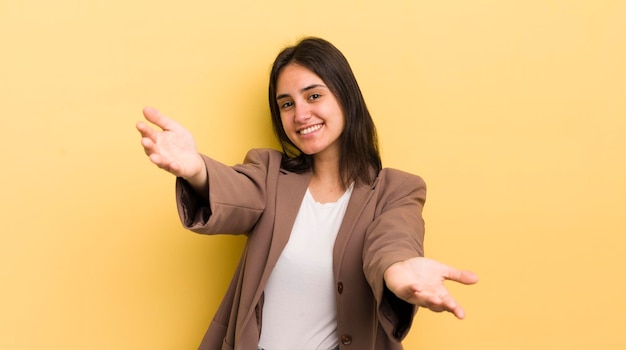 Jonge Spaanse vrouw die vrolijk lacht en een warme, vriendelijke, liefdevolle welkomstknuffel geeft en zich gelukkig en schattig voelt