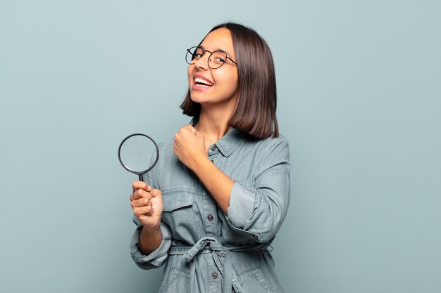 Jonge Spaanse vrouw die zich gelukkig, positief en succesvol voelt, gemotiveerd wanneer ze voor een uitdaging staat of goede resultaten viert