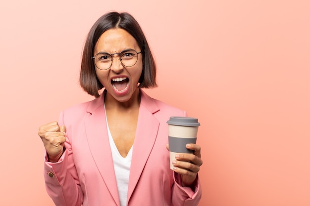 Jonge Spaanse vrouw die zich gelukkig, positief en succesvol voelt, overwinning, prestaties of veel geluk viert