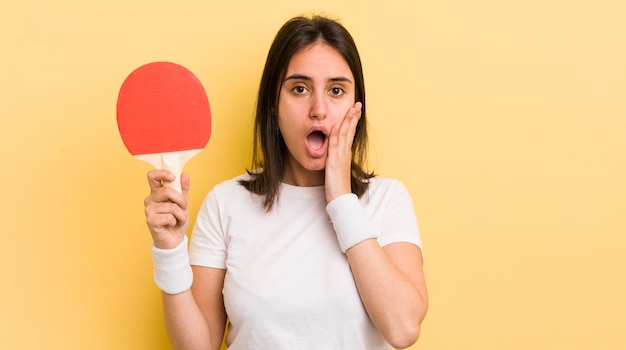 Jonge Spaanse vrouw die zich geschokt en bang pingpongconcept voelt