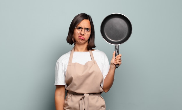 Jonge spaanse vrouw die zich verbaasd en verward voelt, met een domme, verbijsterde uitdrukking op zoek naar iets onverwachts