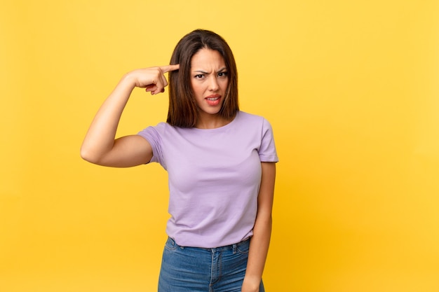 Jonge Spaanse vrouw die zich verward en verbaasd voelt en laat zien dat je gek bent