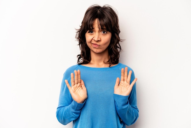 Foto jonge spaanse vrouw geïsoleerd op een witte achtergrond die iemand afwijst die een gebaar van walging toont