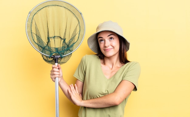 Foto jonge spaanse vrouw haalt haar schouders op, voelt zich verward en onzeker visnetconcept