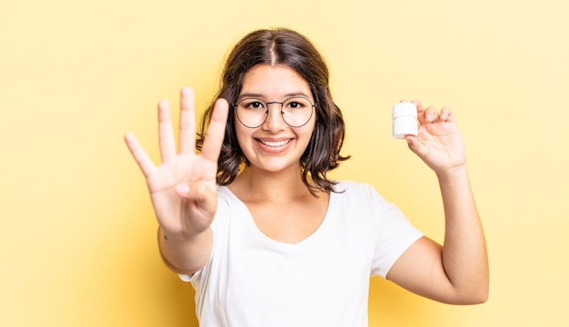 jonge Spaanse vrouw lacht en ziet er vriendelijk uit, met nummer vier. ziekte pillen concept