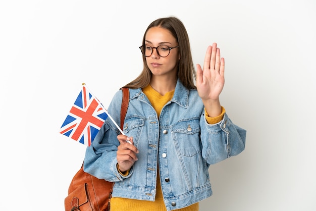 Jonge spaanse vrouw met een vlag van het verenigd koninkrijk geïsoleerd