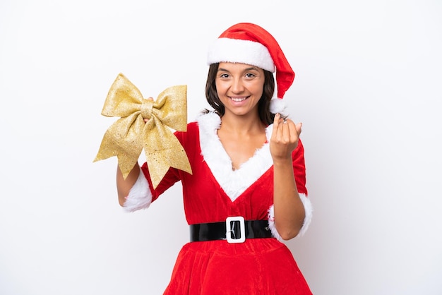 Jonge Spaanse vrouw verkleed als mama noel met een kerststrik geïsoleerd op een witte achtergrond die uitnodigt om met de hand te komen Blij dat je kwam