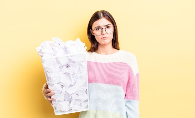 Jonge spaanse vrouw voelt zich verdrietig en zeurt met een ongelukkige blik en huilt. mislukking prullenbak concept